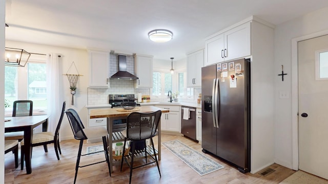 401 5th St NE, Barnesville, MN 56514 - kitchen featuring stainless steel appliances, wall chimney exhaust hood, decorative backsplash, white cabinets, and a sink