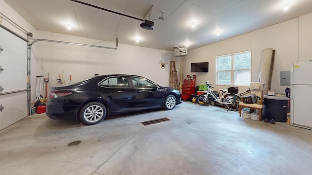 401 5th St NE, Barnesville, MN 56514 - garage with freestanding refrigerator, a garage door opener, and electric panel