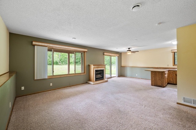 30170 Norway Dr NW, Bradford Twp, MN 55008 - unfurnished living room with light carpet, a ceiling fan, a fireplace, and a textured ceiling