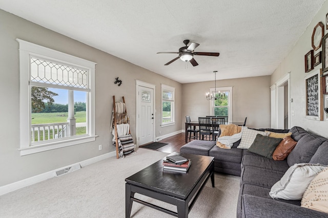18160 Echo Ave, Faribault, MN 55021 - living area featuring a chandelier, a ceiling fan, a textured ceiling, and dark colored carpet