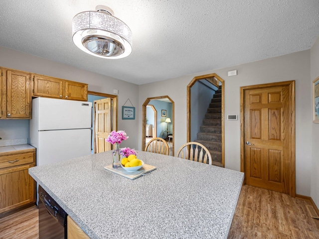 45 Oak Ave S, Maple Lake, MN 55358 - kitchen featuring freestanding refrigerator, light wood-style flooring, dishwasher, a textured ceiling, and a center island