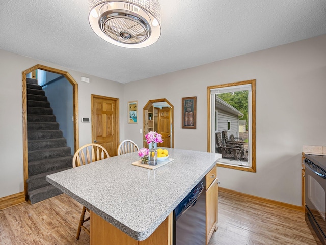 45 Oak Ave S, Maple Lake, MN 55358 - kitchen with black appliances, arched walkways, light wood-type flooring, a kitchen island, and a textured ceiling