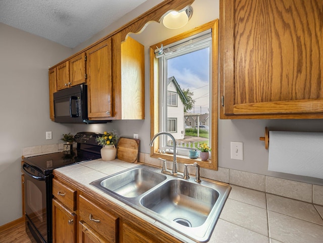 45 Oak Ave S, Maple Lake, MN 55358 - kitchen with black appliances, tile counters, brown cabinets, and a textured ceiling