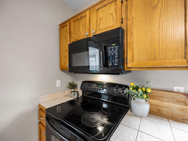45 Oak Ave S, Maple Lake, MN 55358 - kitchen with black appliances, tile countertops, tile patterned floors, and brown cabinets