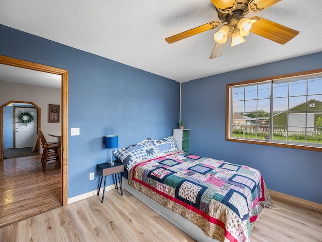 45 Oak Ave S, Maple Lake, MN 55358 - bedroom with wood finished floors, arched walkways, a textured ceiling, and a ceiling fan