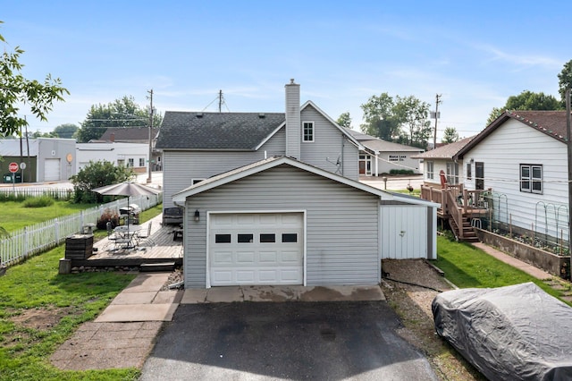 45 Oak Ave S, Maple Lake, MN 55358 - back of house featuring a deck, an outbuilding, driveway, a chimney, and a detached garage
