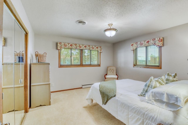 1204 20th Ave S, Moorhead, MN 56560 - bedroom featuring multiple windows, carpet floors, a textured ceiling, and a baseboard radiator