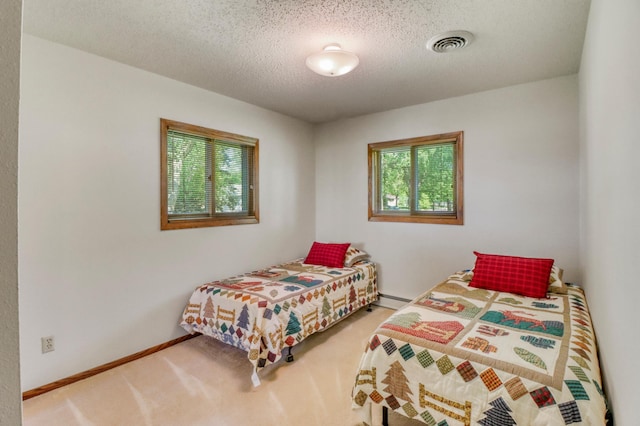 1204 20th Ave S, Moorhead, MN 56560 - bedroom featuring carpet floors, a textured ceiling, and baseboard heating