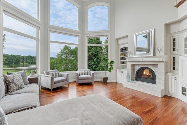3287 Norcrest Ave N, Baytown Twp, MN 55082 - living area featuring hardwood / wood-style flooring, a high ceiling, a tiled fireplace, and built in features