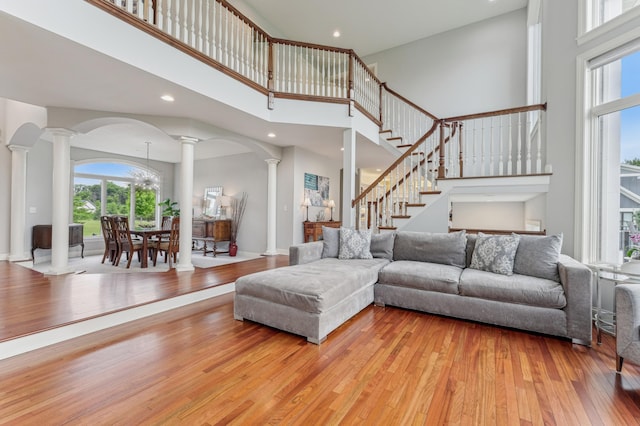3287 Norcrest Ave N, Baytown Twp, MN 55082 - living area with ornate columns, wood-type flooring, a high ceiling, a chandelier, and arched walkways