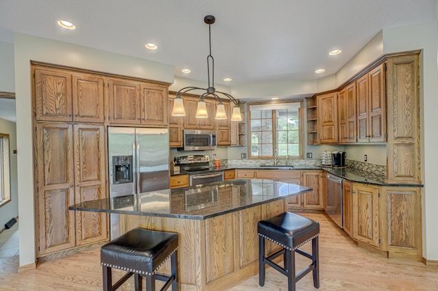 1994 80th St, Somerset, WI 54025 - kitchen featuring stainless steel appliances, open shelves, a breakfast bar, light wood-style floors, and a sink