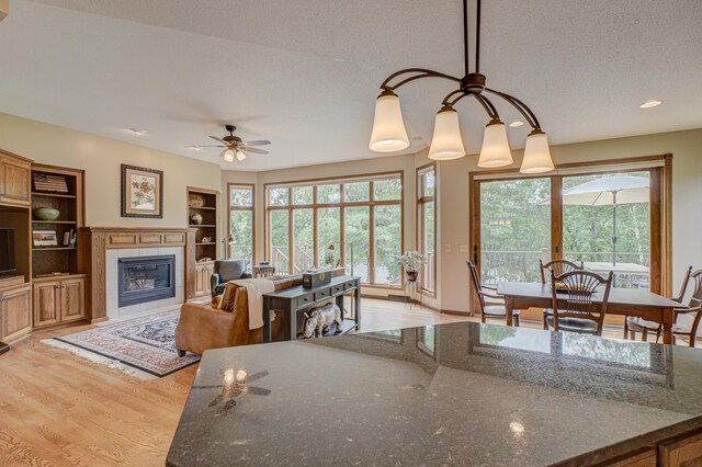 1994 80th St, Somerset, WI 54025 - living room with light wood-type flooring, a fireplace, ceiling fan, a textured ceiling, and recessed lighting
