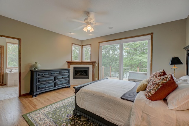 1994 80th St, Somerset, WI 54025 - bedroom with access to outside, light wood-type flooring, a fireplace, ensuite bath, and ceiling fan