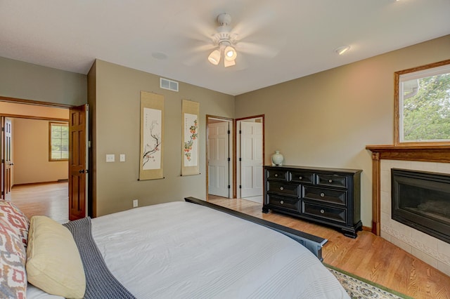 1994 80th St, Somerset, WI 54025 - bedroom featuring light wood finished floors, a tiled fireplace, and ceiling fan