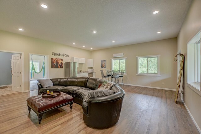 1994 80th St, Somerset, WI 54025 - living room with a wall mounted air conditioner, light wood-style floors, recessed lighting, and baseboards