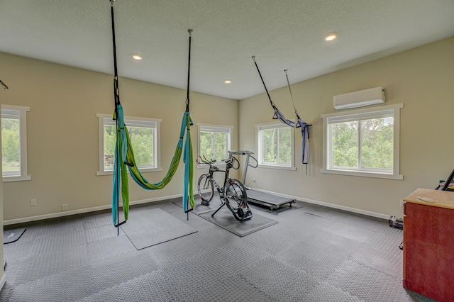 1994 80th St, Somerset, WI 54025 - workout area with an AC wall unit, baseboards, recessed lighting, and a textured ceiling