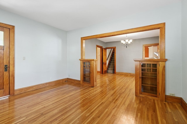228 Sidney St W, Saint Paul, MN 55107 - unfurnished room with light wood finished floors, stairs, and a chandelier