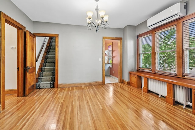 228 Sidney St W, Saint Paul, MN 55107 - unfurnished dining area with an AC wall unit, radiator, light wood finished floors, and a chandelier