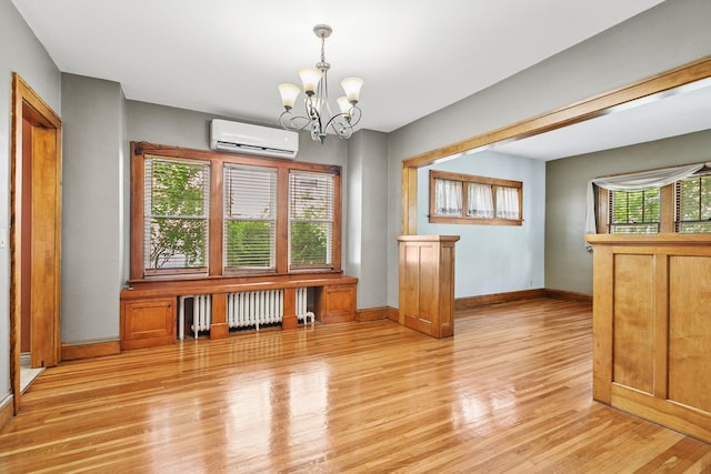 228 Sidney St W, Saint Paul, MN 55107 - unfurnished dining area featuring a wall mounted AC, radiator, light wood-style flooring, and a chandelier