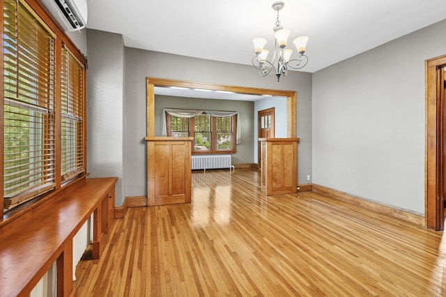 228 Sidney St W, Saint Paul, MN 55107 - unfurnished dining area with radiator, light wood-style floors, a wall mounted air conditioner, and a chandelier
