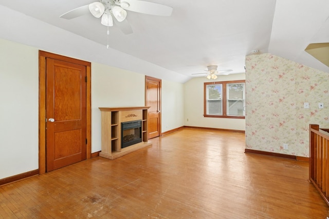228 Sidney St W, Saint Paul, MN 55107 - unfurnished living room with ceiling fan, light wood-style flooring, vaulted ceiling, and a glass covered fireplace