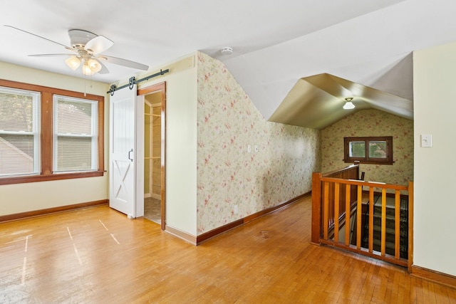 228 Sidney St W, Saint Paul, MN 55107 - empty room featuring wallpapered walls, a barn door, wood finished floors, a ceiling fan, and a smoke detector