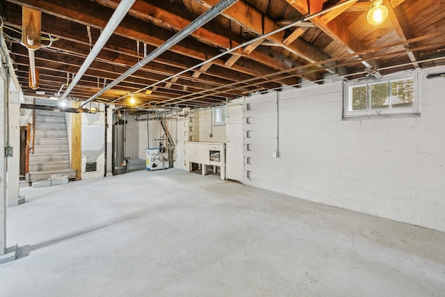 228 Sidney St W, Saint Paul, MN 55107 - basement featuring water heater, healthy amount of natural light, and stairs