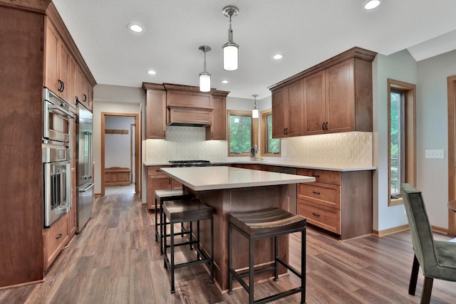6033 Sargent Ct N, Lino Lakes, MN 55110 - kitchen featuring recessed lighting, dark wood-style floors, decorative backsplash, light countertops, and a kitchen bar