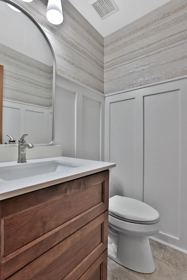 6033 Sargent Ct N, Lino Lakes, MN 55110 - bathroom with vanity, toilet, and a decorative wall