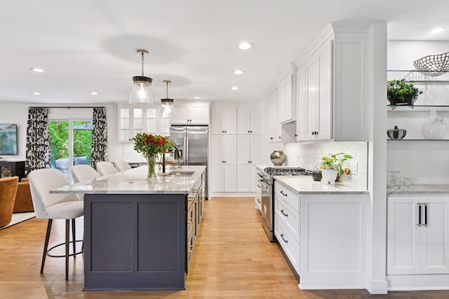 3930 Cottage Ln, Minnetonka, MN 55305 - kitchen featuring high end stove, white cabinetry, a breakfast bar, light stone counters, and recessed lighting