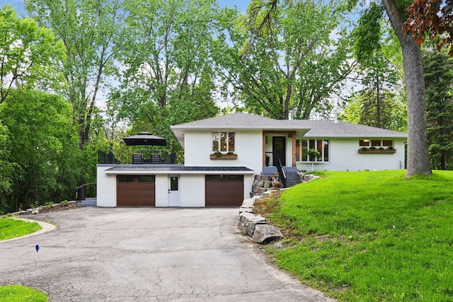 3930 Cottage Ln, Minnetonka, MN 55305 - view of front of house featuring driveway, a front yard, brick siding, and an attached garage