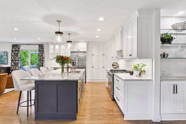 3930 Cottage Ln, Minnetonka, MN 55305 - kitchen featuring high end range, white cabinets, a breakfast bar area, light wood finished floors, and recessed lighting