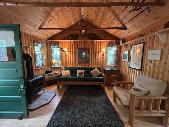 N11464 Fremont Ave, Chicog Twp, WI 54888 - living room with a wood stove, wooden ceiling, wood walls, and wood finished floors