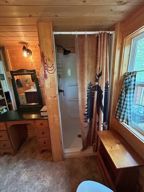 N11464 Fremont Ave, Chicog Twp, WI 54888 - full bathroom with a stall shower, wooden walls, and toilet