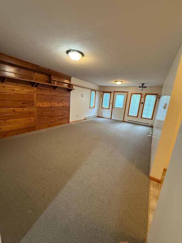 306 1st St, Belview, MN 56214 - unfurnished room with healthy amount of natural light, a baseboard radiator, a textured ceiling, and light carpet