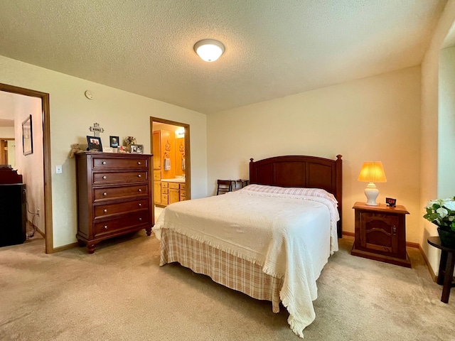 727 Cloud St NW, Bemidji, MN 56601 - bedroom with light colored carpet, a textured ceiling, ensuite bathroom, and baseboards