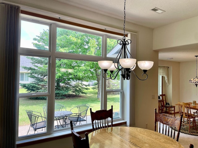 727 Cloud St NW, Bemidji, MN 56601 - dining room featuring a chandelier, healthy amount of natural light, and a textured ceiling