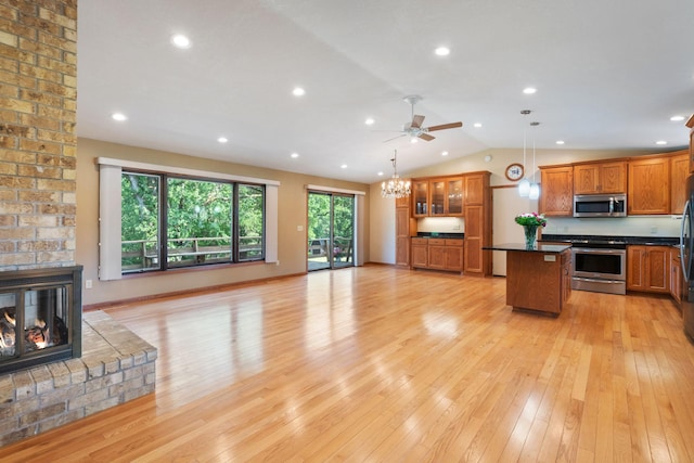 17855 Round Lake Blvd NW, Andover, MN 55304 - kitchen featuring appliances with stainless steel finishes, dark countertops, open floor plan, brown cabinets, and a brick fireplace