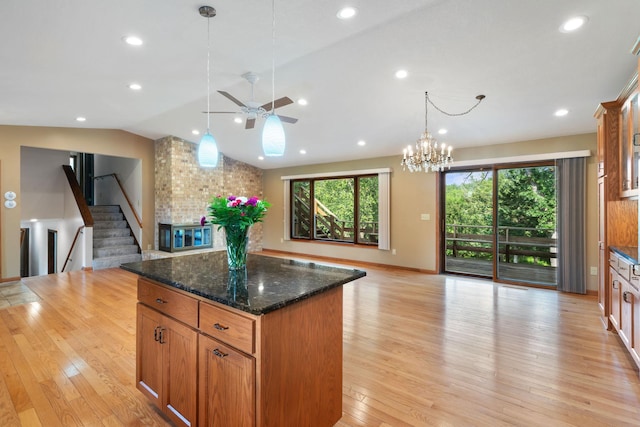 17855 Round Lake Blvd NW, Andover, MN 55304 - kitchen featuring open floor plan, a kitchen island, light wood finished floors, a ceiling fan, and dark stone countertops