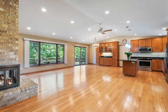 17855 Round Lake Blvd NW, Andover, MN 55304 - kitchen with stainless steel appliances, open floor plan, a fireplace, dark countertops, and vaulted ceiling