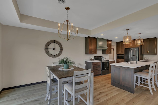 5815 Rivers Edge Dr, Saint Cloud, MN 56303 - kitchen featuring appliances with stainless steel finishes, a sink, a chandelier, custom exhaust hood, and light countertops