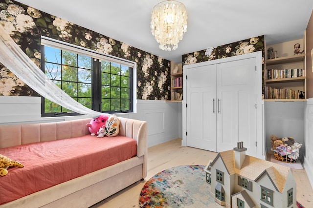 6855 Timber Crest Dr, Maple Grove, MN 55311 - bedroom with a wainscoted wall, a chandelier, wallpapered walls, wood finished floors, and a closet