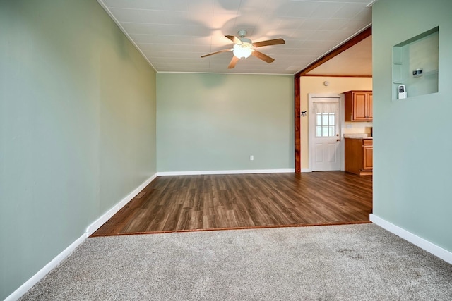 29827 Elfmanns Dr, Wilson Twp, MN 55987 - unfurnished living room with ceiling fan, baseboards, crown molding, dark wood finished floors, and dark colored carpet