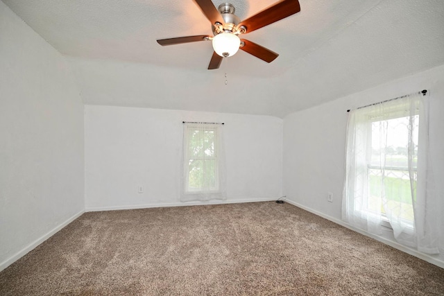29827 Elfmanns Dr, Wilson Twp, MN 55987 - carpeted empty room with a ceiling fan, baseboards, a textured ceiling, and vaulted ceiling