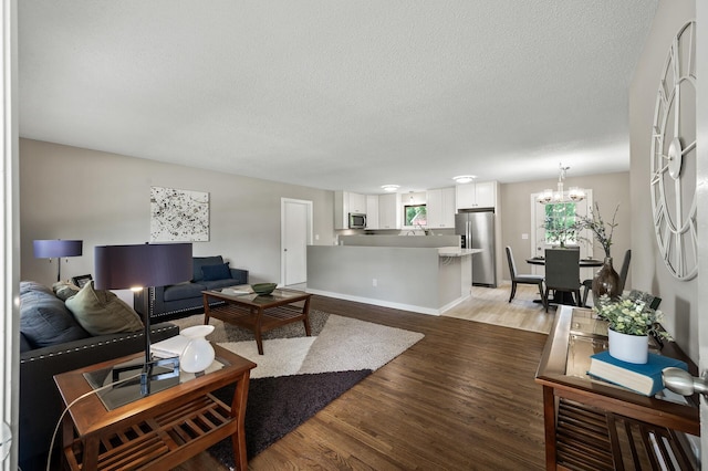 17900 Weaver Lake Dr, Maple Grove, MN 55311 - living room with light wood-style flooring, a textured ceiling, a chandelier, and baseboards