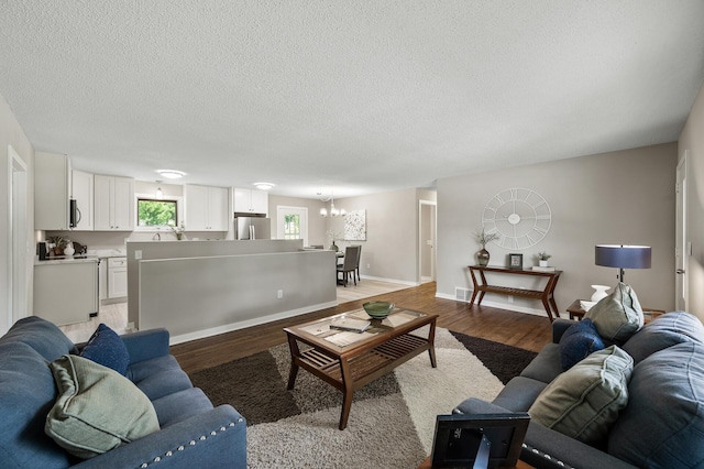 17900 Weaver Lake Dr, Maple Grove, MN 55311 - living area featuring light wood-style floors, a chandelier, a textured ceiling, and baseboards