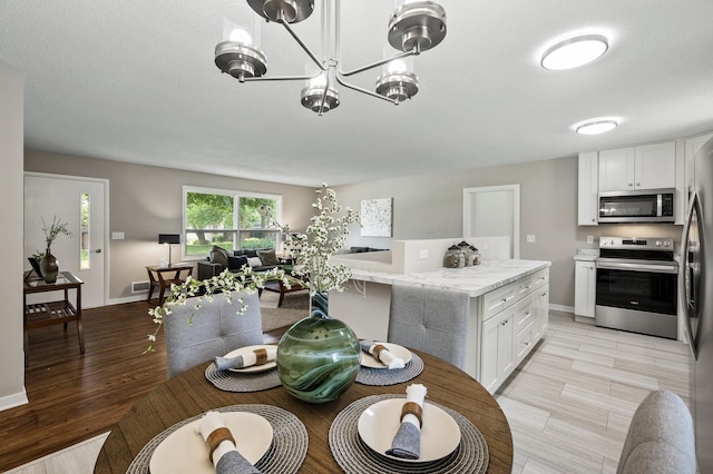 17900 Weaver Lake Dr, Maple Grove, MN 55311 - dining room featuring a chandelier, baseboards, and light wood finished floors