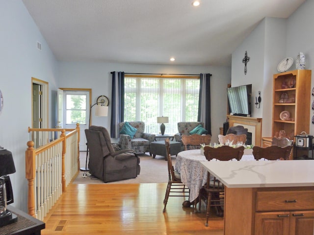17098 Pheasant Meadow Ln SW, Prior Lake, MN 55372 - kitchen featuring light wood-style floors, recessed lighting, open floor plan, vaulted ceiling, and a kitchen breakfast bar