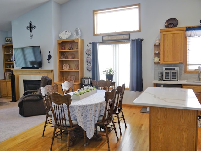 17098 Pheasant Meadow Ln SW, Prior Lake, MN 55372 - dining space with light wood finished floors, a fireplace, and high vaulted ceiling