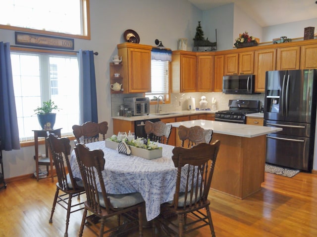 17098 Pheasant Meadow Ln SW, Prior Lake, MN 55372 - kitchen featuring fridge with ice dispenser, stainless steel range with gas stovetop, light wood-style floors, light countertops, and backsplash